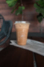 An iced latte inside of a plastic, Foxtail Coffee branded to-go cup. 